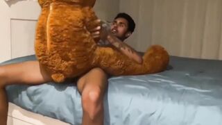 Gay twink takes big cock in his mouth while stuffed with his favorite teddy bear