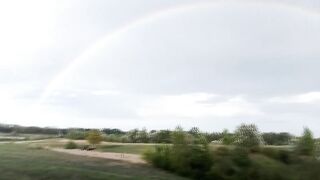 Gay boy pisses pee under rainbow in summer rain