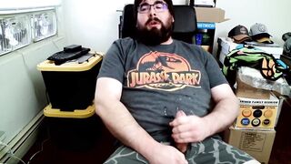 Bear in boxers strokes hard while jerking off to Jurassic Park on his computer chair