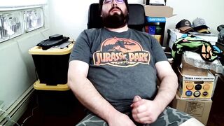 Bear in boxers strokes hard while jerking off to Jurassic Park on his computer chair