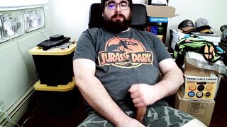 Bear in boxers strokes hard while jerking off to Jurassic Park on his computer chair
