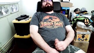 Bear in boxers strokes hard while jerking off to Jurassic Park on his computer chair
