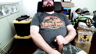 Bear in boxers strokes hard while jerking off to Jurassic Park on his computer chair