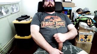 Bear in boxers strokes hard while jerking off to Jurassic Park on his computer chair