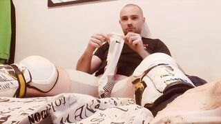 Hockey player jacking off in shinpads and cleats with his glove covered hands
