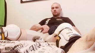 Hockey player jacking off in shinpads and cleats with his glove covered hands