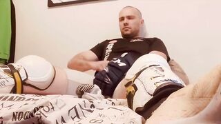 Hockey player jacking off in shinpads and cleats with his glove covered hands